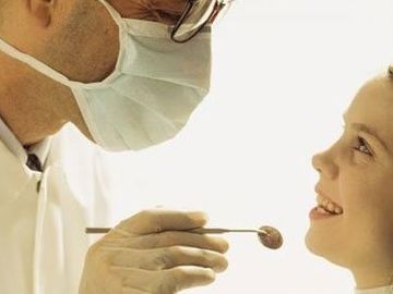 Luis Sánchez Ferreiro odontólogo examinando a una niña